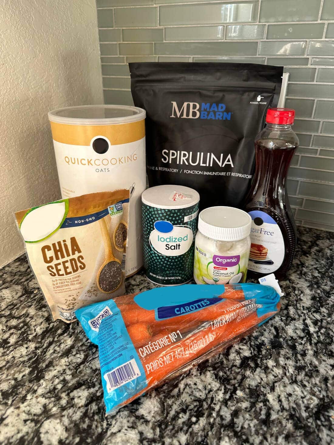 Ingredients for no-bake horse treats displayed on a kitchen counter including oats, carrots, and spirulina