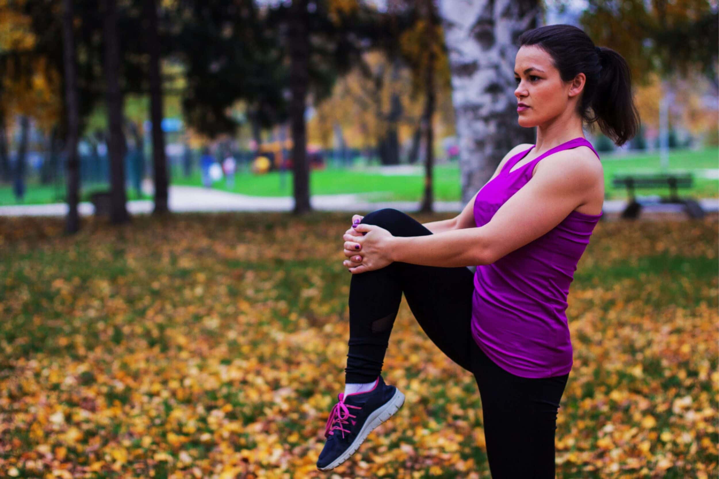 image of woman performing a held knee lift in a standing position