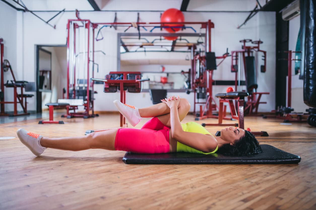 image of woman performing a held knee lift while lying down
