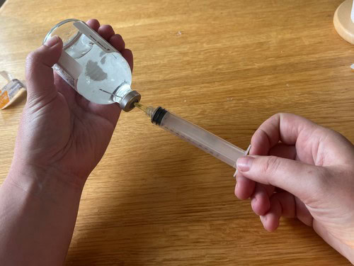 puncturing a medication vial with a needle